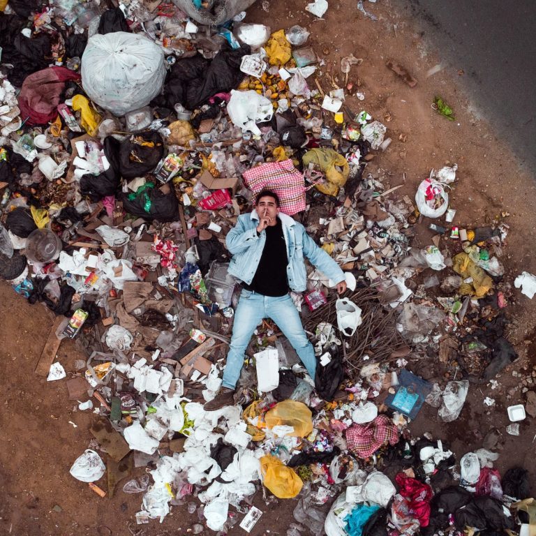 man lying on garbage pile in aerial photography